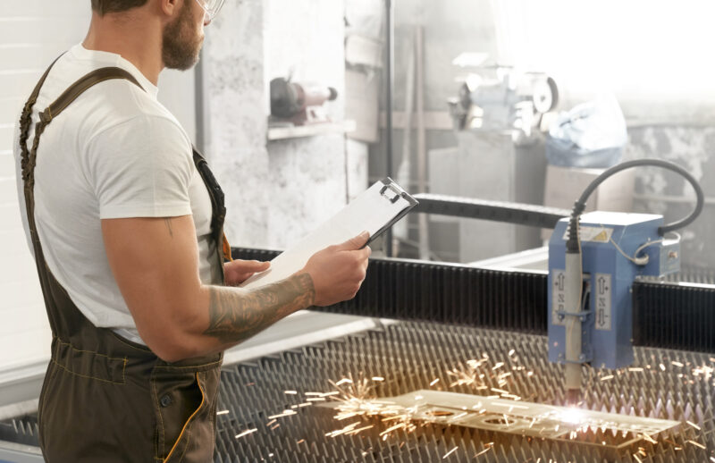 Engineer controlling plasma laser cutting metal.