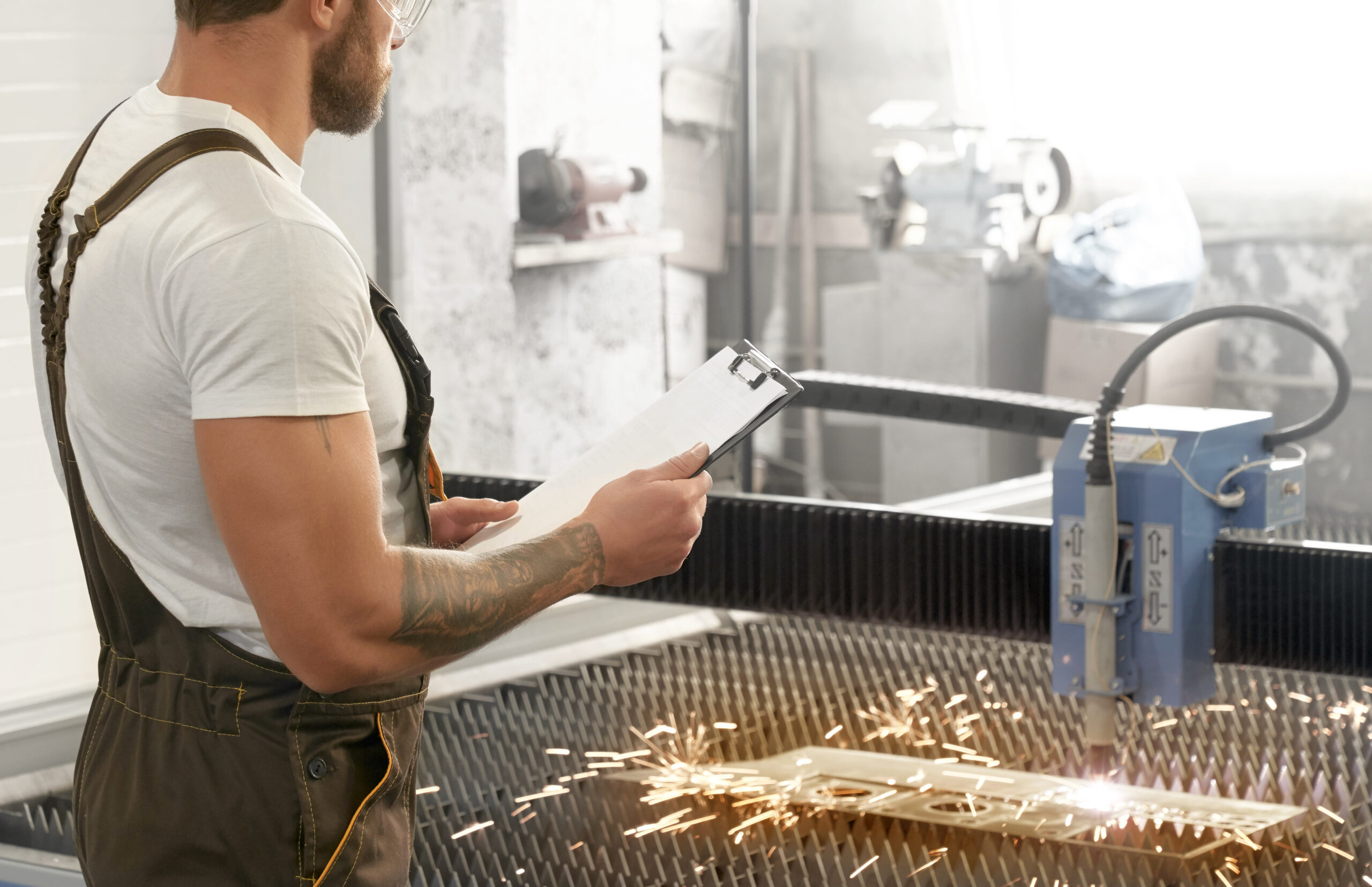 Engineer controlling plasma laser cutting metal.
