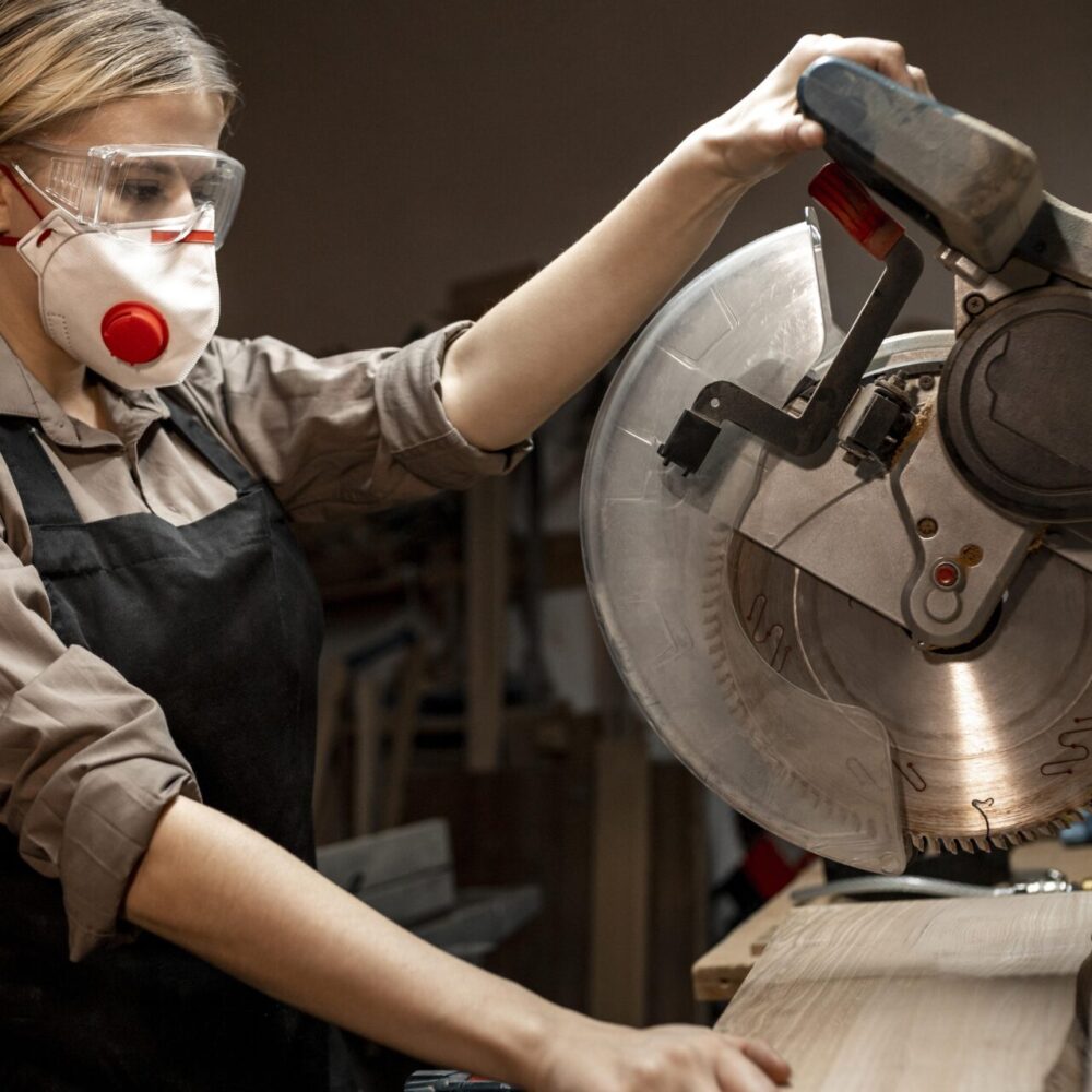 Side view female carpenter using round saw