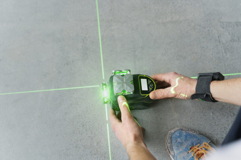 Construction worker holding tool with green light