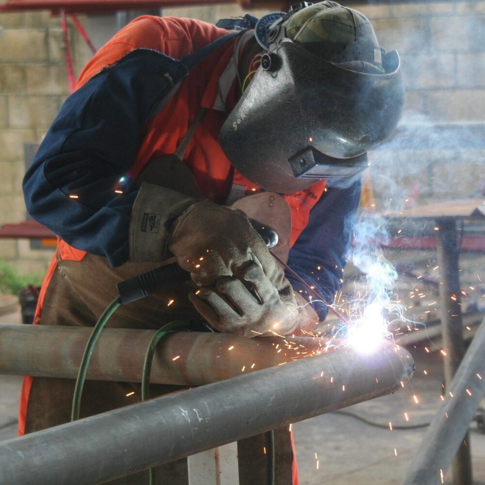 worker cleaning welding equipment