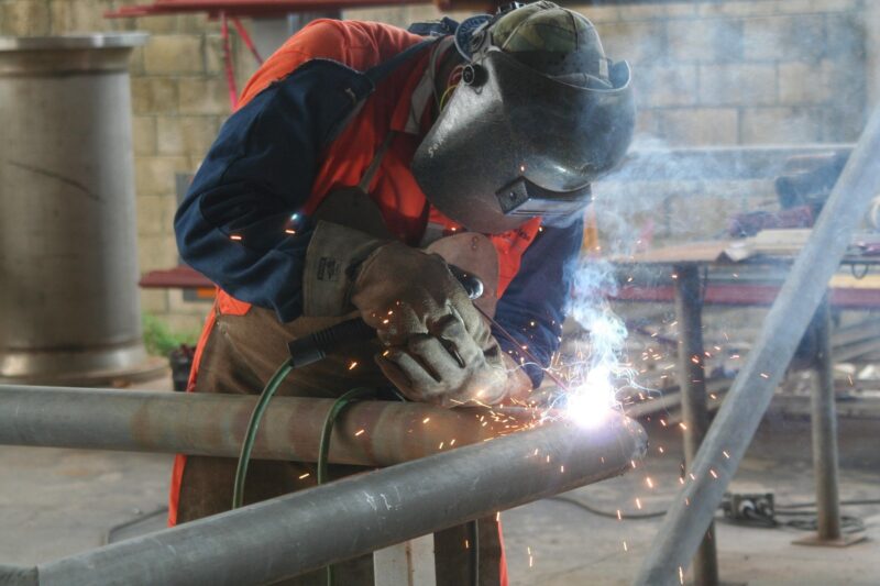 worker cleaning welding equipment